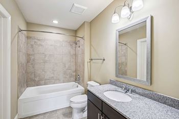 A bathroom with a white tub, toilet, and sink.